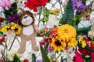 A stuffed animal and flowers are seen along a memorial wall for the Texas flood victims. More than 160 people are still missing